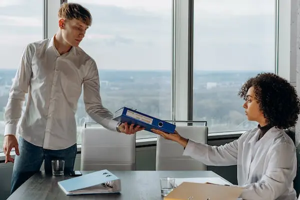 AI Marketing Analytics: Unlocking it's Potential 6 man giving a book to a woman